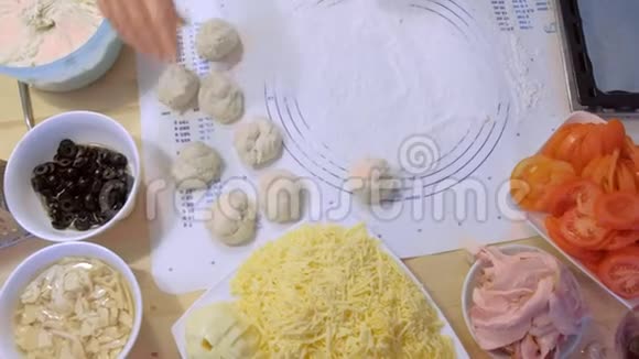女人用不同的配料做比萨饼的面团双手特写视频的预览图