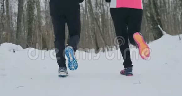 两个跑步者穿着运动鞋在公园冬天跑步的脚的特写已婚夫妇参加体育活动视频的预览图