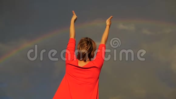在彩虹中向天空伸出大拇指并表示和平的女人视频的预览图