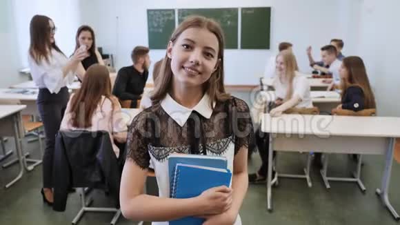一位年轻的俄罗斯高中毕业生在她班背景下的肖像视频的预览图