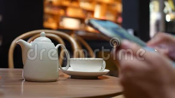 一个女人坐在咖啡馆里使用智能手机的手的特写女孩使用移动应用程序4k视频的预览图