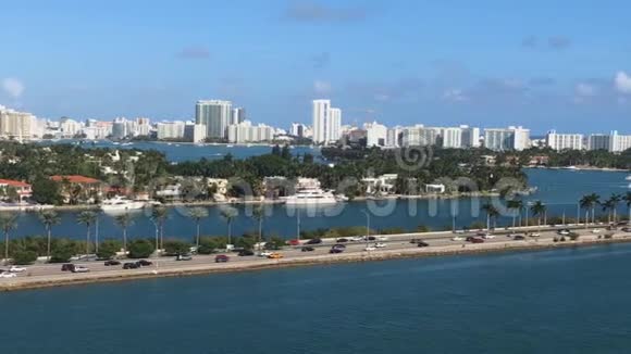 美丽的城市和道路有汽车和棕榈树从游轮上经过海洋旅程背景视频的预览图
