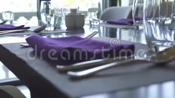餐桌设置餐厅概念把棉布餐巾眼镜勺子叉子和刀子都贴在餐桌上视频的预览图