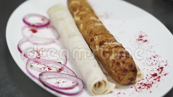 把美味的新鲜烤肉串洒在大盘子上配上紫罗兰洋葱和皮塔现代食品视频的预览图