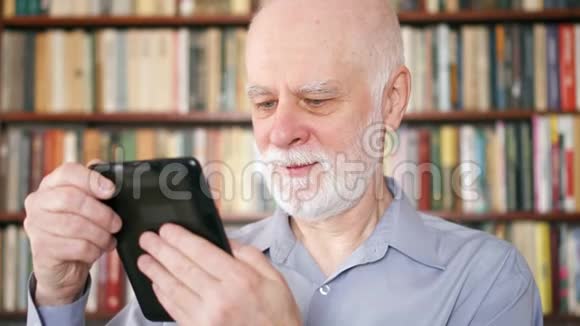 年长的老人在家放松阅读享受退休生活的电子书背景书架视频的预览图