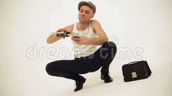 一个老式的蹲在罐顶上的板条箱和一个面包男孩的帽子坐着香烟把钱扔掉视频的预览图