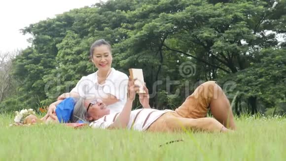 老两口夫妻俩在公园野餐心情愉快地休息着视频的预览图