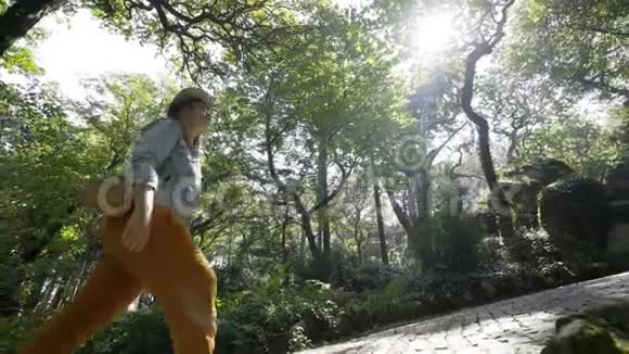 妇女行走在树木和植物之间的小径上视频的预览图