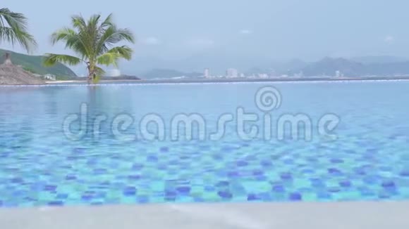 在蓝海和城市全景背景下度假酒店的豪华无限游泳池豪华酒店提供游泳池可观看视频的预览图