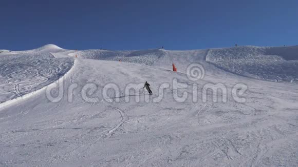 滑雪者在斜坡上滑雪快速左右转弯喷雪刹车视频的预览图
