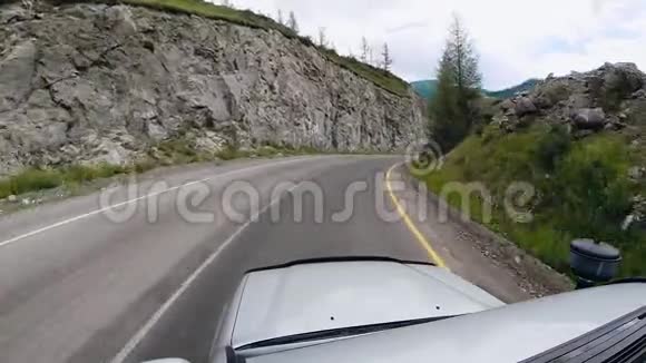 观点行驶在公路上的沥青上在山上沿着一条路行驶从高处经过的车视频的预览图