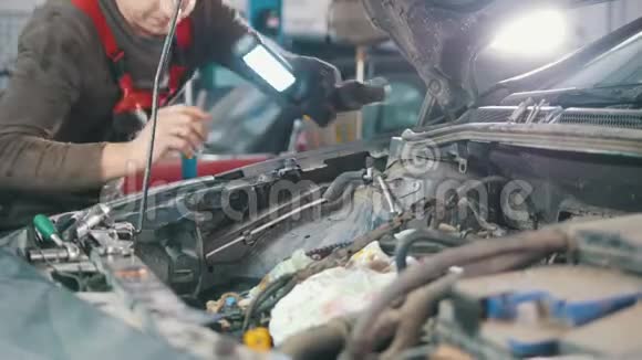 机械师检查和修理汽车发动机汽车修理在车间工作大修在引擎视频的预览图