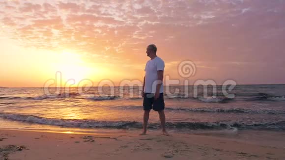 男子微笑的游客看日出在海滨竖起大拇指视频的预览图