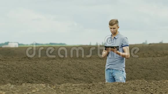 一个年轻的农民正在一堆堆肥附近工作有机肥料无农药农业和视频的预览图