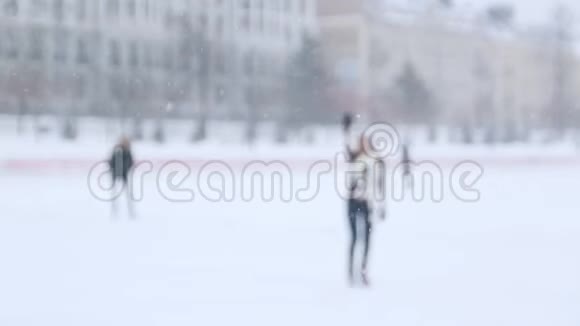 一个年轻的女人在外面滑冰看到她的朋友用一只手向他们挥手在镜头附近溜冰视频的预览图