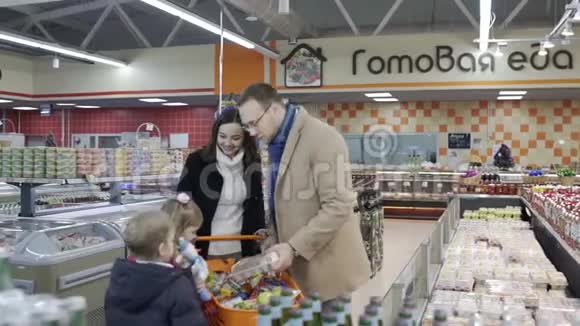 年轻的家庭在杂货店一起挑选农产品慢动作视频的预览图