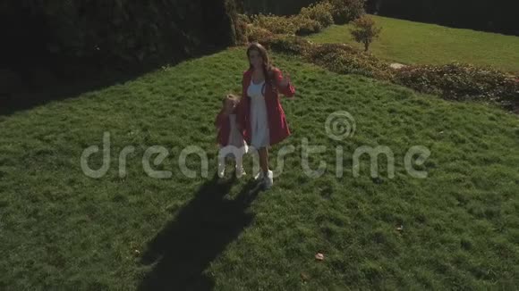 小女孩和她的母亲挥动双手把空气亲吻送到相机上无人驾驶飞机中弹视频的预览图