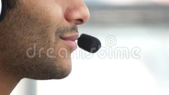 微笑的男人用耳机微型说话视频的预览图