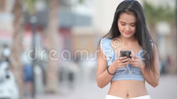 年轻快乐的亚洲游客在城市海滩打电话视频的预览图