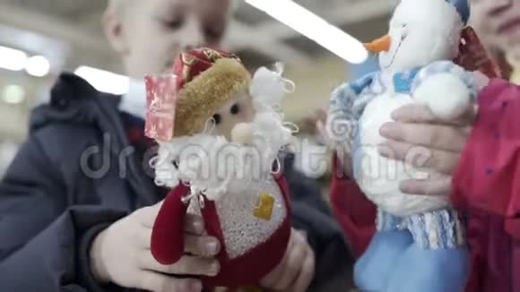 可爱的女孩和男孩在购物中心玩圣诞玩具关门视频的预览图