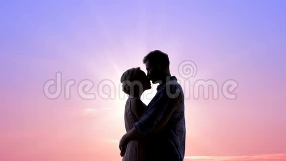 恋爱中的情侣尽情拥抱阳光灿烂的日出温柔的感情亲吻视频的预览图