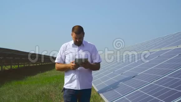 一名男子在太阳能发电厂的平板电脑上做笔记视频的预览图