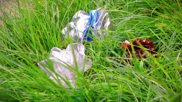 塑料瓶垃圾躺在草丛中污染地球的概念视频的预览图