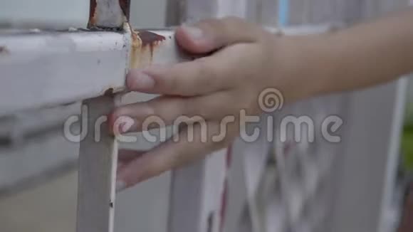 一个孤独的女孩紧紧地抓住生锈的金属栅栏视频的预览图