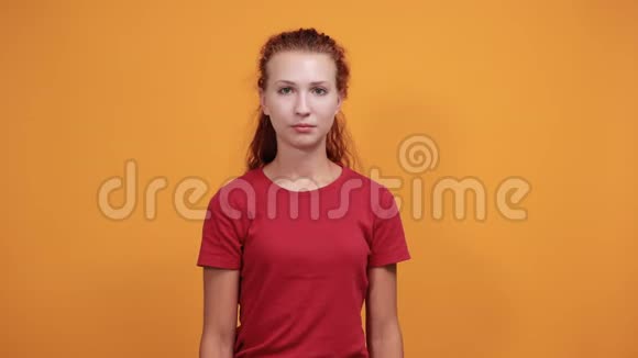 穿红色衬衫的漂亮年轻女人不做任何手势停止滑稽的鬼脸视频的预览图