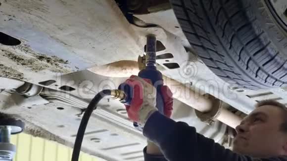 一名汽车服务工人拧下机器底部的螺栓它修理汽车检查性能视频的预览图