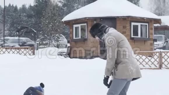 年轻的父亲和儿子互相扔雪球家庭享受冬天视频的预览图
