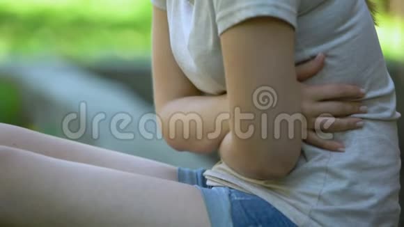 女孩在户外感到胃痛消化系统问题疼痛抽筋视频的预览图
