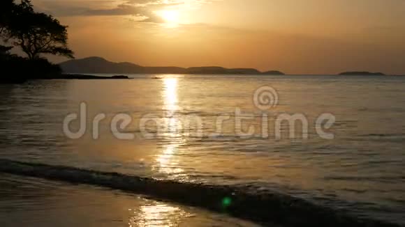 4K片热带海滩海面上美丽的日落视频的预览图