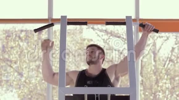 运动生活方式肌肉运动员与美丽的运动身体拉在模拟器在力量锻炼在健身房视频的预览图