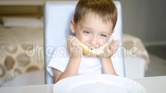 一个孩子慢吞吞地坐在桌子旁吃瓜视频的预览图