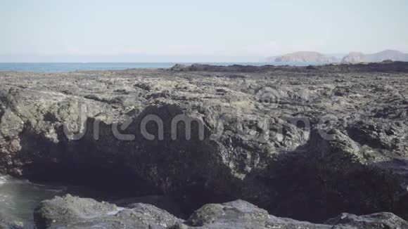 汹涌的海浪拍打在岩石海岸上的近距离斜射视频的预览图