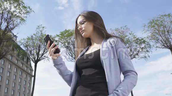自信优雅的女士戴着太阳镜打电话享受交流视频的预览图