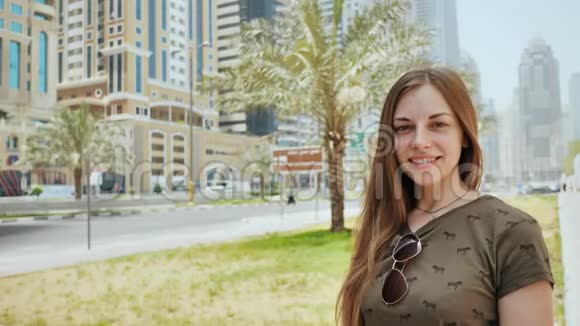 迪拜一条街道背景上一个微笑女孩的肖像视频的预览图