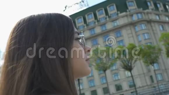 戴着太阳镜的迷人女士在城市散步青少年健康城市娱乐视频的预览图