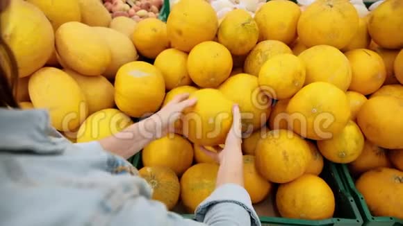女人在超市选择水果一个年轻女孩买食物是为了素食健康食品鲜黄色蔬菜视频的预览图