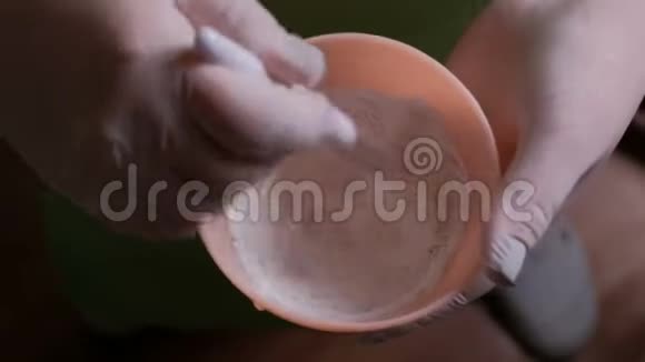 将配料混合在粉红色橡胶杯中的过程白手套上美容师或实验室技术人员的手视频的预览图