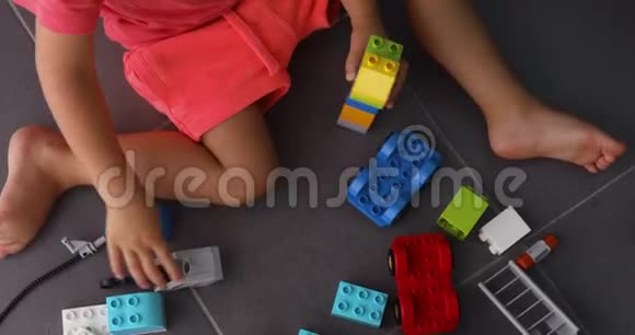 儿童在室内玩许多彩色塑料积木视频的预览图