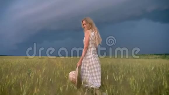 年轻漂亮受启发的女孩在雨天的田野里散步自由的概念视频的预览图