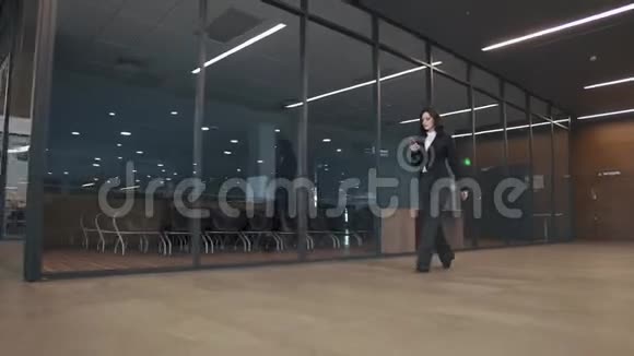 穿着西装的年轻女子走在办公楼的走廊上视频的预览图