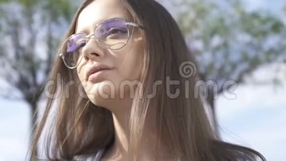 戴墨镜的微笑女士在城市紫外线防护中享受夏日阳光视频的预览图
