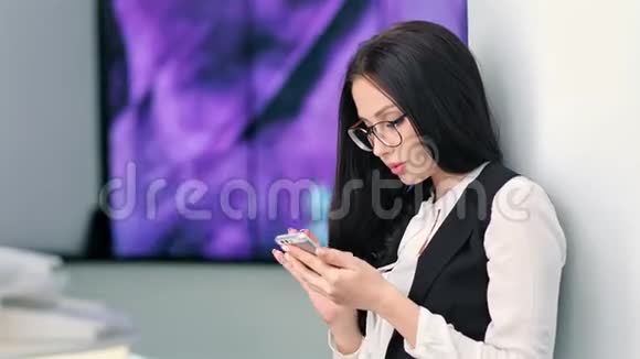 在未来的高科技展览会上戴着智能手机眼镜的漂亮年轻女商人视频的预览图