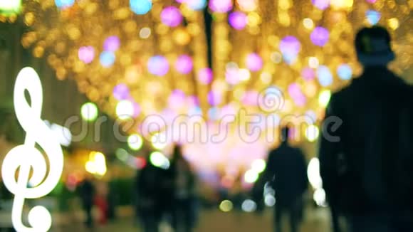 傍晚模糊的人们沿着灯火通明的行人区散步视频的预览图