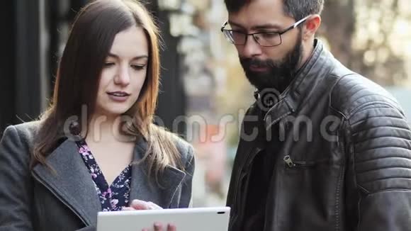 商人们手里拿着平板电脑站在街上说话看着什么视频的预览图