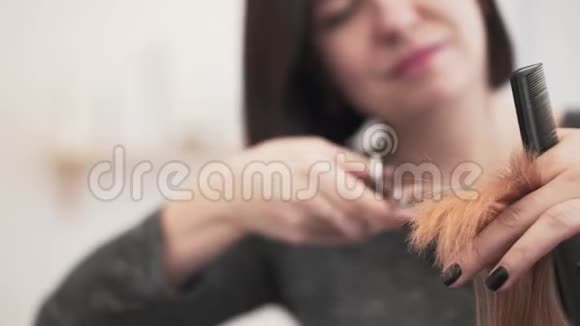 理发师用黑色指甲油剪她的客户的红色头发视频的预览图