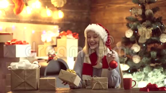 圣诞树附近壁炉旁的年轻女士礼物新年概念圣诞树礼物和礼物视频的预览图